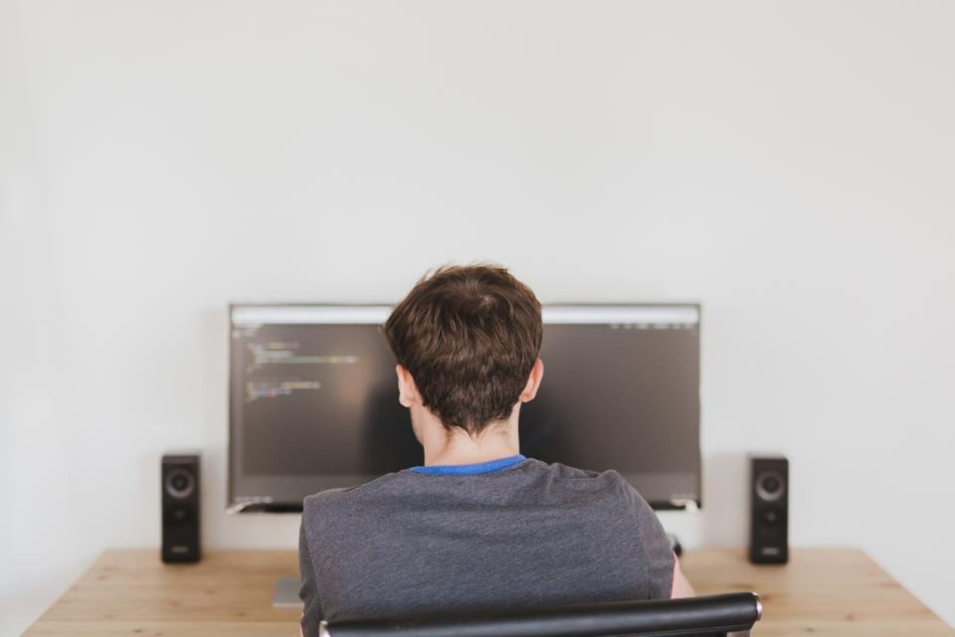 Programador a trabalhar em frente a um monitor com código